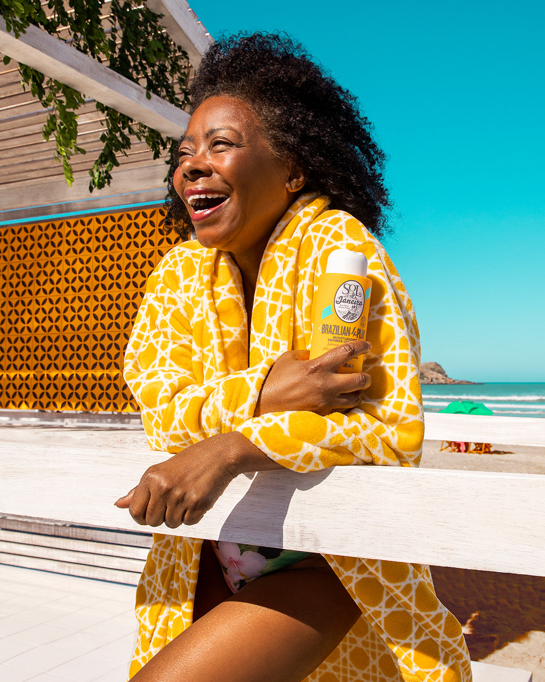 A mom holding her favorite shower gel by the beach. Mother's Day Gifting.
