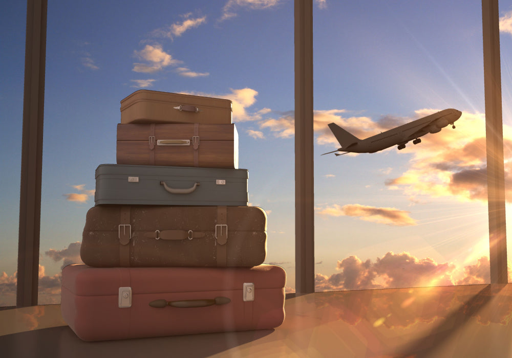 Picture of suitcases and airplane taking off in the background