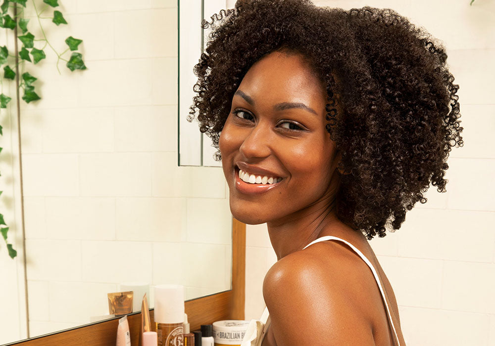 Model smiling with curly hair