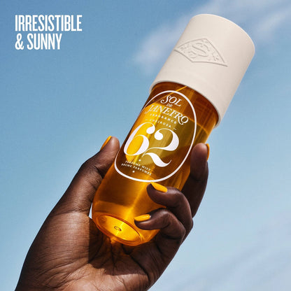 text on image says &quot;irresistible &amp; sunny&quot; with the bottle of sol de janeiro cheirosa 62 perfume mist in a models hand