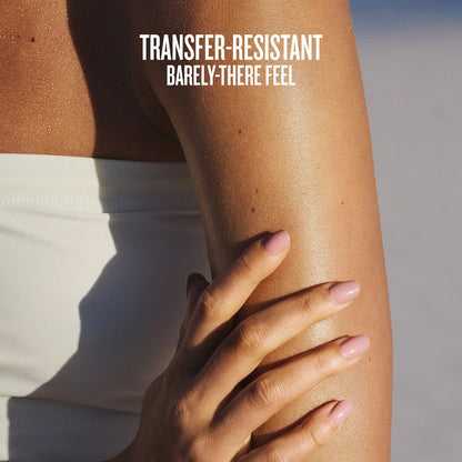 Text on image reads transfer-resistant barely-there feel. This is an image of a close up of model having the sol de janeiro glowmotions glow body oil on her arm and you can see how glowy and hydrated it makes her skin look